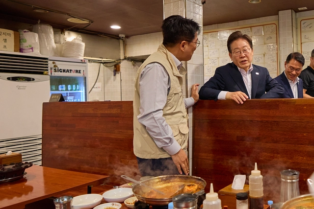 이재명 대통령이 26일 점심 식사를 위해 방문한 서울 용산 대통령실 인근 한 식당에서 시민과 대화하고 있다. 대통령실 제공.