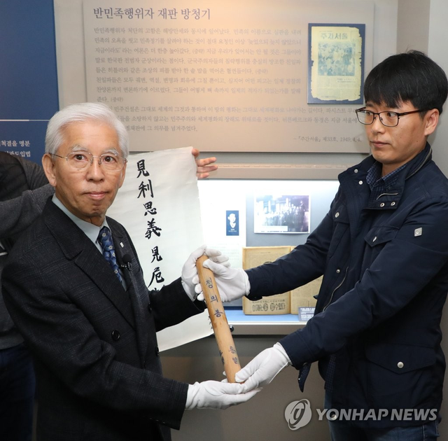 백범 김구 암살범 안두희 전 육군 소위를 살해한 박기서 (왼쪽)씨가 지난 2018년 10월 24일 서울 용산구 식민지역사박물관에서 안두희를 처단하는 데 쓴 ‘정의봉’을 기증하고 있다. [연합뉴스 자료사진]