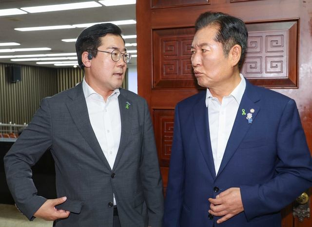 더불어민주당 전당대회에 출마한 정청래(오른쪽) 의원과 박찬대 의원이 지난 3일 국회에서 열린 비공개 의원총회장 앞에서 대화하고 있다. [연합뉴스]