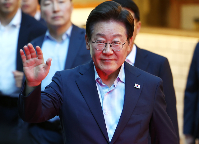 이재명 대통령이 지난 11일 서울 광화문 인근 한식당에서 나오며 시민들에게 손을 흔들고 있다.  [연합뉴스]
