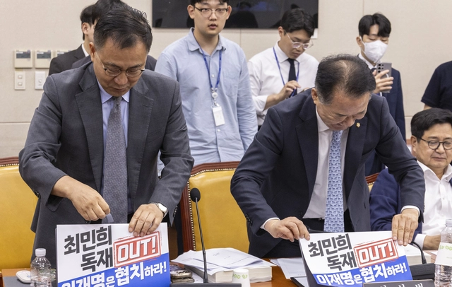14일 국회 과학기술정보방송통신위에서 열린 배경훈 과학기술정보통신부 장관 후보자 인사청문회에서 야당 간사인 최형두 국민의힘 의원과 신성범 의원이 여당 주도 방송3법 강행처리에 항의하는 내용의 인쇄물을 노트북에 붙이고 있다. 이날 배경훈 후보자 청문회는 국민의힘 의원들이 국회에서 처리된 방송3법에 항의하는 인쇄물을 노트북에 붙이는 것을 두고 여야 갈등이 계속되면서 오전 청문 진행을 하지 못한 채 정회됐다.<연합뉴스 사진>