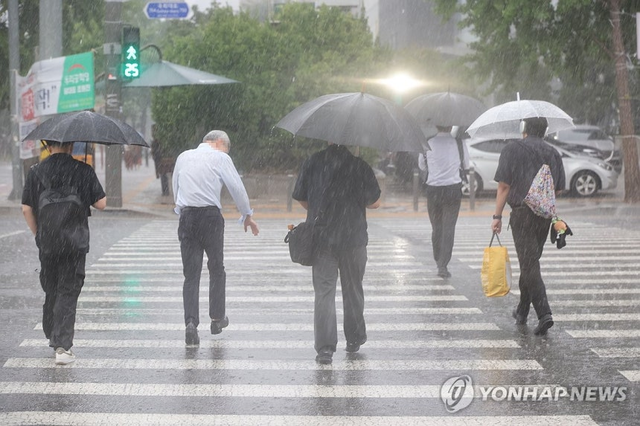 서울 영등포구 여의도 국회 인근에서 시민들이 우산을 쓰고 이동하고 있다. 연합뉴스