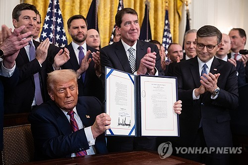 도널드 트럼프 미국 대통령이 18일(현지시간) 지니어스법에 서명하고 이를 들어보이고 있다. 연합뉴스