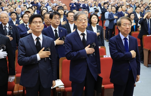 19일 서울 동작구 국립현충원 현충관에서 열린 이승만 전 대통령 서거 60주기 추모식에서 정운찬 전 국무총리, 김황식 이승만건국대통령기념사업회 이사장, 김문수 상임고문이 국기에 경례하고 있다.  [연합뉴스]