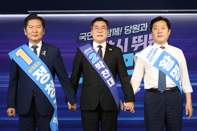 더불어민주당 대표 선거에 출마한 정청래(왼쪽부터) 의원과 박찬대 의원, 최고위원 선거에 출마한 황명선 의원이 20일 서울 여의도 당사에서 열린 8·2 전당대회 순회 경선 영남권 합동연설회에서 손을 잡고 인사하고 있다. [연합뉴스]