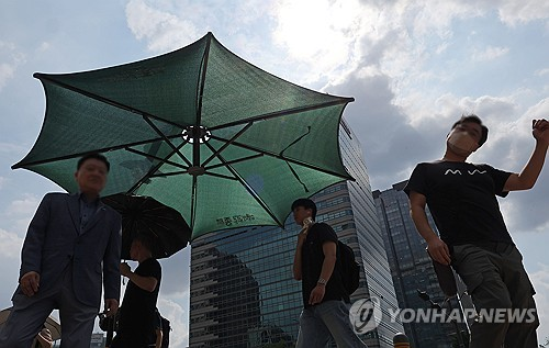 더운 날씨가 이어지는 23일 서울 광화문광장에서 시민들이 뜨거운 햇볕을 맞으며 걸어가고 있다. [연합뉴스]