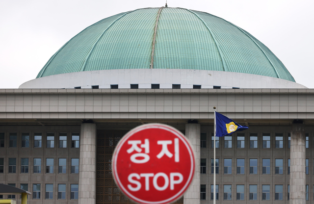 국회의사당 정문 입구에 설치된 ‘정지’ 교통 표지판 너머로 본청이 보인다. [연합뉴스]