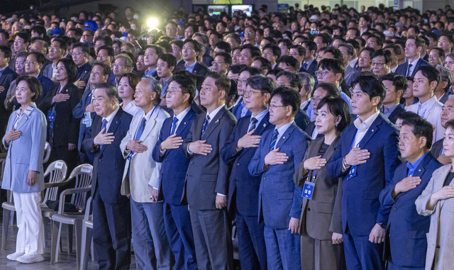 김병기 더불어민주당 원내대표 등 참석자들이 지난 2일 고양 킨텍스에서 열린 전국당원대회에서 국기에 경례하고 있다. [공동취재]
