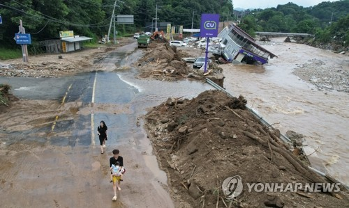 지난달 20일 경기 가평군에서 집중호우로 편의점 건물이 무너져 내린 가운데 관광객들이 대피하고 있다. [연합뉴스]
