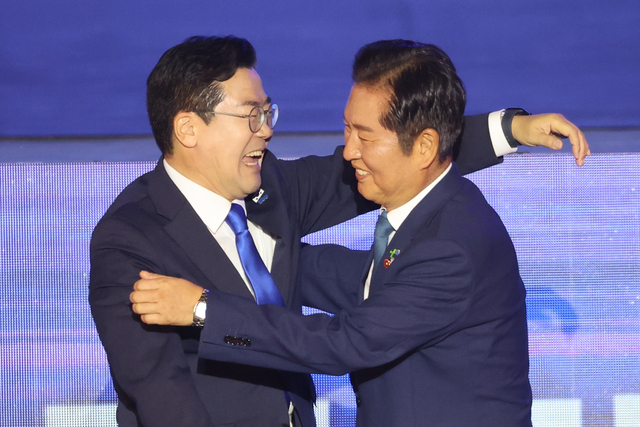 정청래(오른쪽) 더불어민주당 대표가 지난 2일 고양 킨텍스에서 열린 전국당원대회에서 선의의 경쟁을 펼쳤던 박찬대 의원과 포옹하고 있다. [연합뉴스]