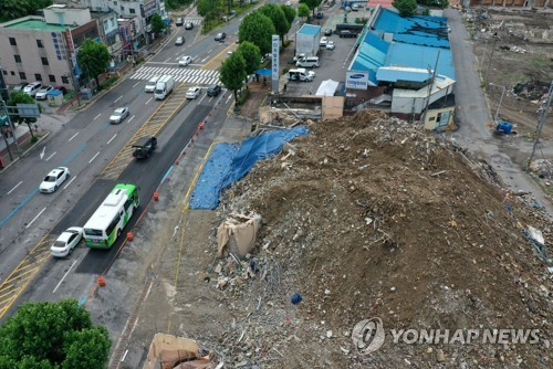 광주 학동 재개발지역 철거건물 붕괴 사고 현장 앞 도로를 버스가 지나고 있다. [광주=연합뉴스]