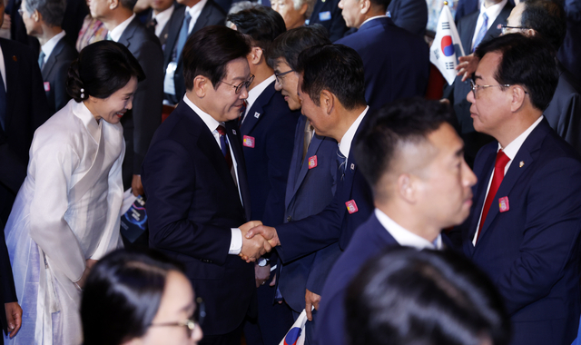 이재명 대통령이 15일 서울 세종문화회관에서 열린 80주년 광복절 경축식에서 정청래 더불어민주당 대표와 인사하고 있다. [대통령실통신사진기자단]