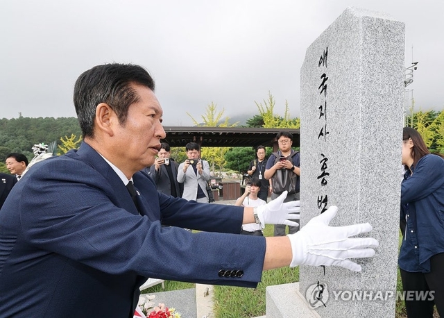 정청래 더불어민주당 대표가 27일 대전 유성구 국립대전현충원 홍범도 장군 묘역을 찾아 참배한 뒤 묘비를 어루만지고 있다. [연합뉴스]