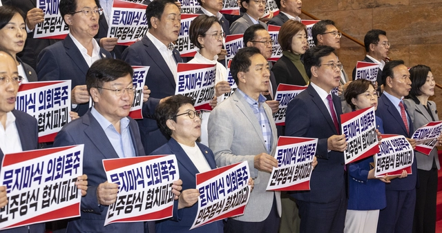 국민의힘 송언석 원내대표를 비롯한 의원들이 27일 국회 본청 계단에서 열린 '묻지마식 의회폭주 민주당식 협치파괴' 규탄대회에서 손팻말을 들고 구호를 외치고 있다. 국민의힘은 이날 본회의에서 당이 추천한 국가인권위원 2명에 대한 선출이 더불어민주당 등 반대표 다수로 부결되자 이에 반발해 퇴장한 뒤 규탄대회를 개최했다.<연합뉴스 사진>
