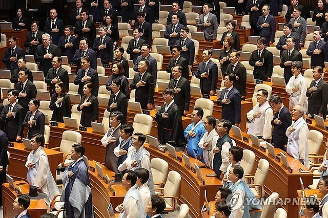1일 서울 여의도 국회에서 열린 정기국회 개회식에서 한복과 상복을 입은 여야 의원들이 국기에 대한 경례를 하고 있다. 연합뉴스