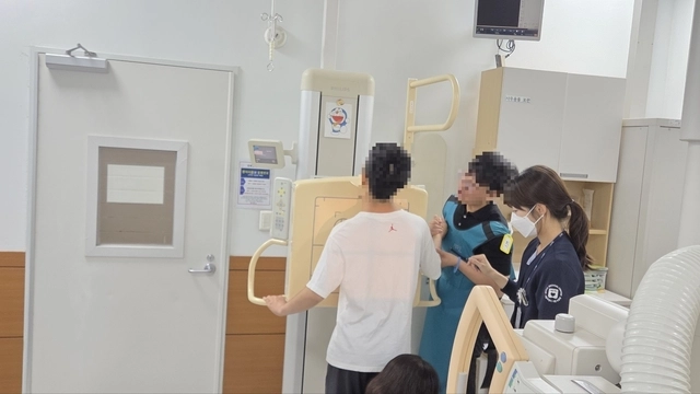 자폐스펙트럼 환자와 사회복지사가 4일 서울의료원 건강증진센터에서 엑스레이 촬영을 위한 준비를 하고 있다.