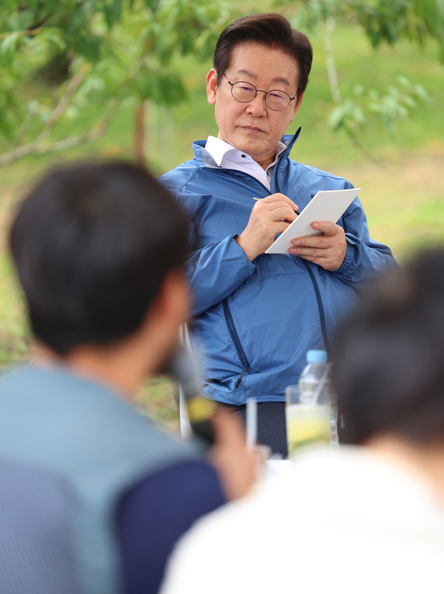 이재명 대통령이 16일 세종시 전동면 조일농원에서 열린 청년 농업인 간담회에서 참석자 발언을 메모하며 경청하고 있다. [연합뉴스]