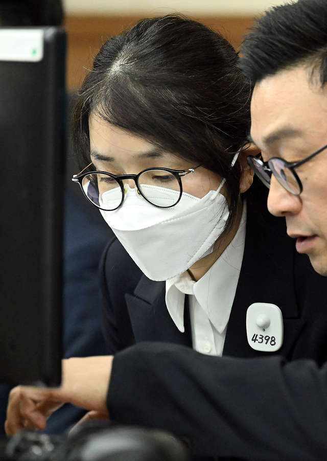 도이치모터스 주가조작 혐의와 통일교 금품수수 의혹 등으로 구속기소된 김건희씨의 첫 재판이 24일 오후에 열렸다. 김 여사가 법정에 들어와 변호사와 대화하고 있다. [사진공동취재단]