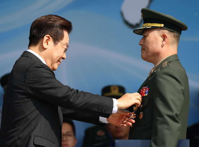 이재명 대통령이 1일 충남 계룡대 대연병장에서 열린 건군 77주년 국군의 날 기념행사에서 박정훈 해병 대령에게 훈장을 수여하고 있다. [연합뉴스]
