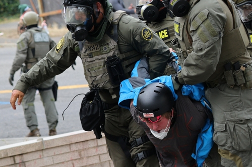미국 연방요원들이 4일(현지시간) 오리건주 포틀랜드의 이민세관단속국(ICE) 본부 앞에서 시위 참가자를 체포하고 있다. [로이터=연합뉴스]