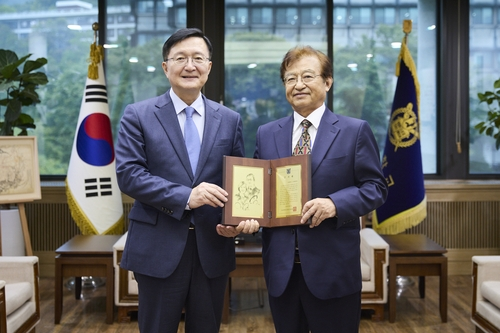 지난 13일 서울대 관악캠퍼스에서 유홍림(왼쪽) 서울대 총장이 자대 출신 재미 의사 조철영씨(오른쪽)에게 감사패를 전달하는 모습. [서울대학교 제공]