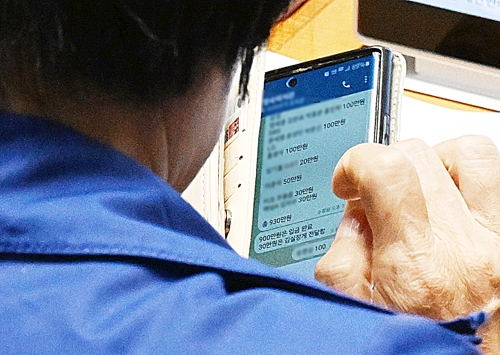 국정감사 기간 딸 결혼식으로 논란을 빚은 국회 과학기술정보방송통신위원장인 더불어민주당 최민희 의원이 26일 국회 본회의장에서 축의금과 관련한 텔레그램 메시지를 보고 있다. 대기업, 언론사 이름과 금액이 적혀 있는 이 메시지는 최 위원장이 축의금을 돌려주는 과정 중 보좌진과 주고받은 내용으로 추정된다. [서울신문 제공·연합뉴스]