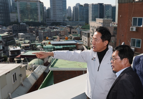 오세훈 서울시장이 28일 서울 구로구 가리봉동 한 건물 옥상에서 가리봉2구역 재개발 관련 설명을 듣고 있다.   [연합뉴스]