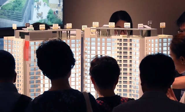 견본주택 모형도를 살펴보는 모델하우스 관람객들. [연합뉴스]
