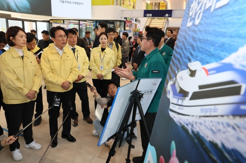 김민석 국무총리가 14일 서울 광진구 한강버스 뚝섬 선착장을 찾아 박진영 서울시 미래한강본부장으로부터 사업 추진 현황 등에 대해 보고받고 있다. [연합뉴스}