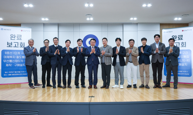 박성주 서울메트로9호선 대표이사(왼쪽 여섯번째)와 임장혁 LG유플러스 기업고객그룹장(오른쪽 여섯번째)을 비롯한 양사 관계자들이 서울 강서구 서울시메트로9호선 사옥에서 열린 구축 완료 보고회에서 기념촬영을 하고 있다. LG유플러스 제공