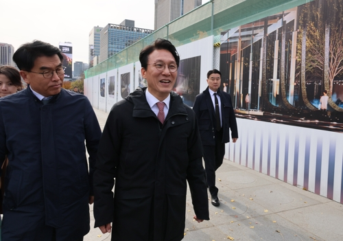 김민석 국무총리가 17일 서울 광화문광장에 조성중인 ‘감사의 정원’ 공사 현장을 찾아 외곽펜스에 그려진 조감도 옆을 지나고 있다. [연합뉴스]