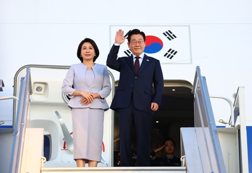 주요 20개국(G20) 정상회의 일정을 마친 이재명 대통령과 김혜경 여사가 23일(현지시간) 다음 국빈 방문지인 튀르키예로 가기 위해 남아프리카공화국 요하네스버그 OR탐보 국제공항에서 공군 1호기에 올라 인사하고 있다. [요하네스버그=연합뉴스]