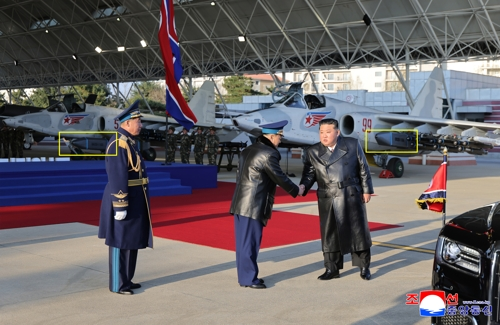 북한 조선중앙통신이 30일 공개한 북한 공군 창설 80주년 기념행사에서 전투기 미그-29 등에 장착된 형태로 처음 포착된 미사일(노란색 네모안). 우리 공군이 운용하는 독일산 장거리 공대지 미사일 ‘타우러스’와 외형이 비슷하다.   [평양 조선중앙통신=연합뉴스]