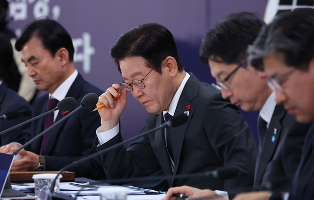 이재명 대통령이 지난 5일 충남 천안시 한국기술교육대학교에서 열린 ‘충남의 마음을 듣다’ 타운홀미팅 간담회에서 참석자 발언 중 자료를 보고 있다. [연합뉴스]