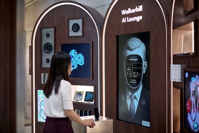 SK네트웍스가 운영하는 그랜드 워커힐 서울 1층에 마련된 ‘워커힐 AI 라운지’에서 한 고객이 AI 매니저 ‘해리스’의 안내를 받고 있다. SK네트웍스 제공