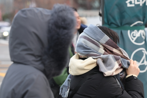 서울 아침 기온이 영하 7도까지 내려가며 강추위가 찾아온 3일 서울 종로구 광화문네거리에서 한 시민이 목도리를 얼굴에 두르고 있다. [연합뉴스]
