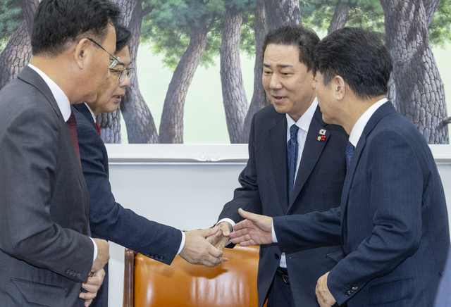 더불어민주당 김병기(오른쪽 두번째) 원내대표와 문진석 원내운영수석부대표(오른쪽 첫번째), 국민의힘 송언석(왼쪽 두번째) 원내대표와 유상범 원내운영수석(왼쪽 첫번째)가 10일 국회 본청에서 만나 12월 임시국회 일정과 본회의 의제 협의를 위해 만나 악수하고 있다.<연합뉴스 사진>