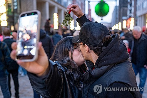 지난 13일 미국 워싱턴DC의 ‘내셔널 겨우살이’ 아래서 키스하는 커플. [로이터=연합뉴스]