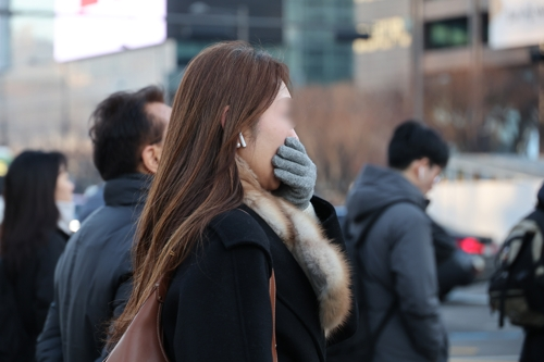 일부 수도권에 한파특보가 발효된 12일 서울 종로구 광화문네거리에서 한 시민이 장갑을 낀 손으로 입을 막고 있다. [연합뉴스]