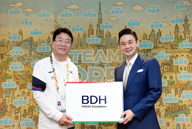 배동현(오른쪽) 이사장이 차우규 선수단장에게 격려금을 전달한 후 기념사진을 촬영을 하고 있다.