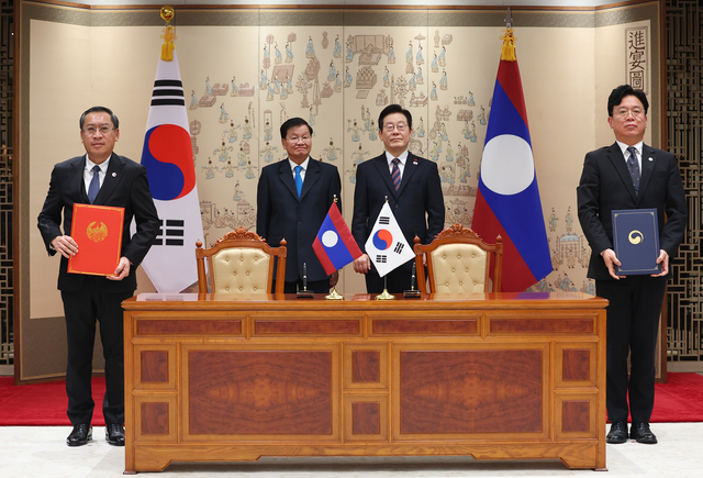 김영훈 노동부 장관과 포싸이 싸이냐선 라오스 노동사회복지부 장관이 15일 용산 대통령실에서 이재명 대통령과 통룬 시술릿 라오스 국가주석이 임석한 가운데 고용허가제 인력송출에 관한 양해각서를 교환한 뒤 기념촬영을 하고 있다.연합뉴스