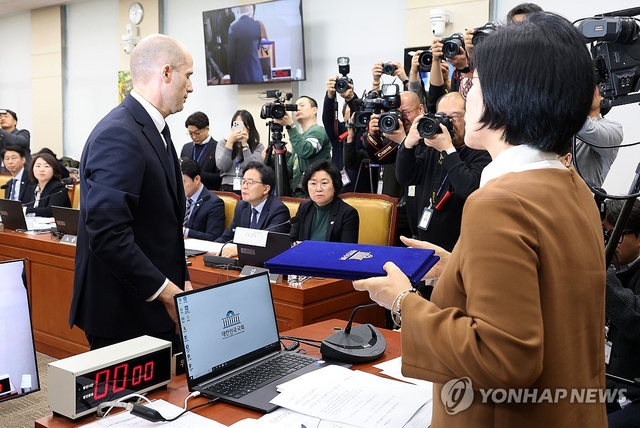 17일 국회 과학기술정보방송통신위원회에서 열린 쿠팡 개인정보 유출 관련 청문회에서 해롤드 로저스 쿠팡 대표이사가 최민희 과방위원장에게 선서문을 제출한 뒤 자리로 향하고 있다. 연합뉴스