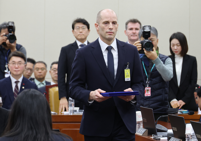 해롤드 로저스 쿠팡 대표이사가 17일 서울 여의도 국회 과학기술정보방송통신위원회에서 열린 쿠팡 침해사고 관련 청문회에 출석해 증인선서 후 최민희 과방위원장에게 선서문을 제출하기 위해 이동하고 있다. [연합뉴스]