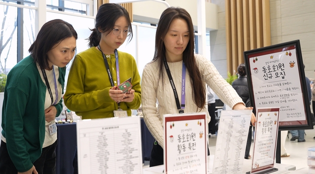 삼성바이오로직스 임직원들이 동호회 신규 회원모집 안내문을 살펴보고 있다. 삼성바이오로직스 제공