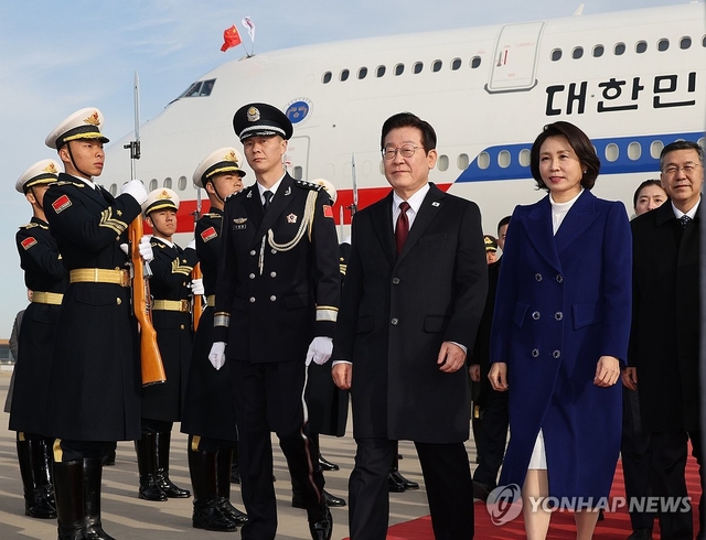 이재명 대통령과 김혜경 여사가 4일 오후 베이징 서우두 공항에 도착한 공군1호기에서 내려 이동하고 있다. 연합뉴스