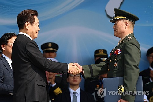 이재명 대통령이 지난 2025년 10월 1일 충남 계룡대 대연병장에서 열린 건군 77주년 국군의 날 기념행사에서 박정훈 해병 대령에게 훈장 수여 후 악수하고 있다.   [연합뉴스]