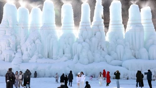 전국 대부분 지역 최저 기온이 영하 10도 안팎으로 떨어진 가운데 11일 충남 청양 알프스마을을 찾은 시민들이 얼음 동산을 배경으로 기념사진을 찍고 있다. [청양=연합뉴스]