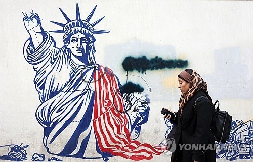 지난 3일 이란 수도 테헤란 시내 거리에 그려져 있는 반미 벽화 앞을 한 여성이 지나가고 있다.  EPA 연합뉴스