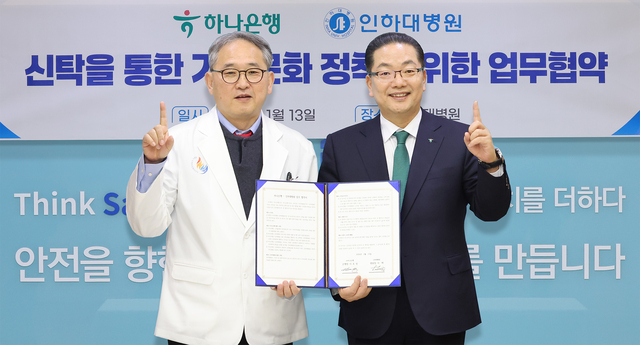 이호성(오른쪽) 하나은행장이 이택 인하대병원장 겸 의료원장과 협약서를 들고 기념촬영을 하고 있다. [하나은행 제공]
