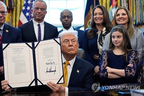 트럼프 대통령이 14일(현지시간) 백악관에서 공립학교에서 저지방우유가 아닌 일반우유 제공을 허용하는 내용의 법안에 서명한 뒤 기념촬영을 하고 있다. AP 연합뉴스